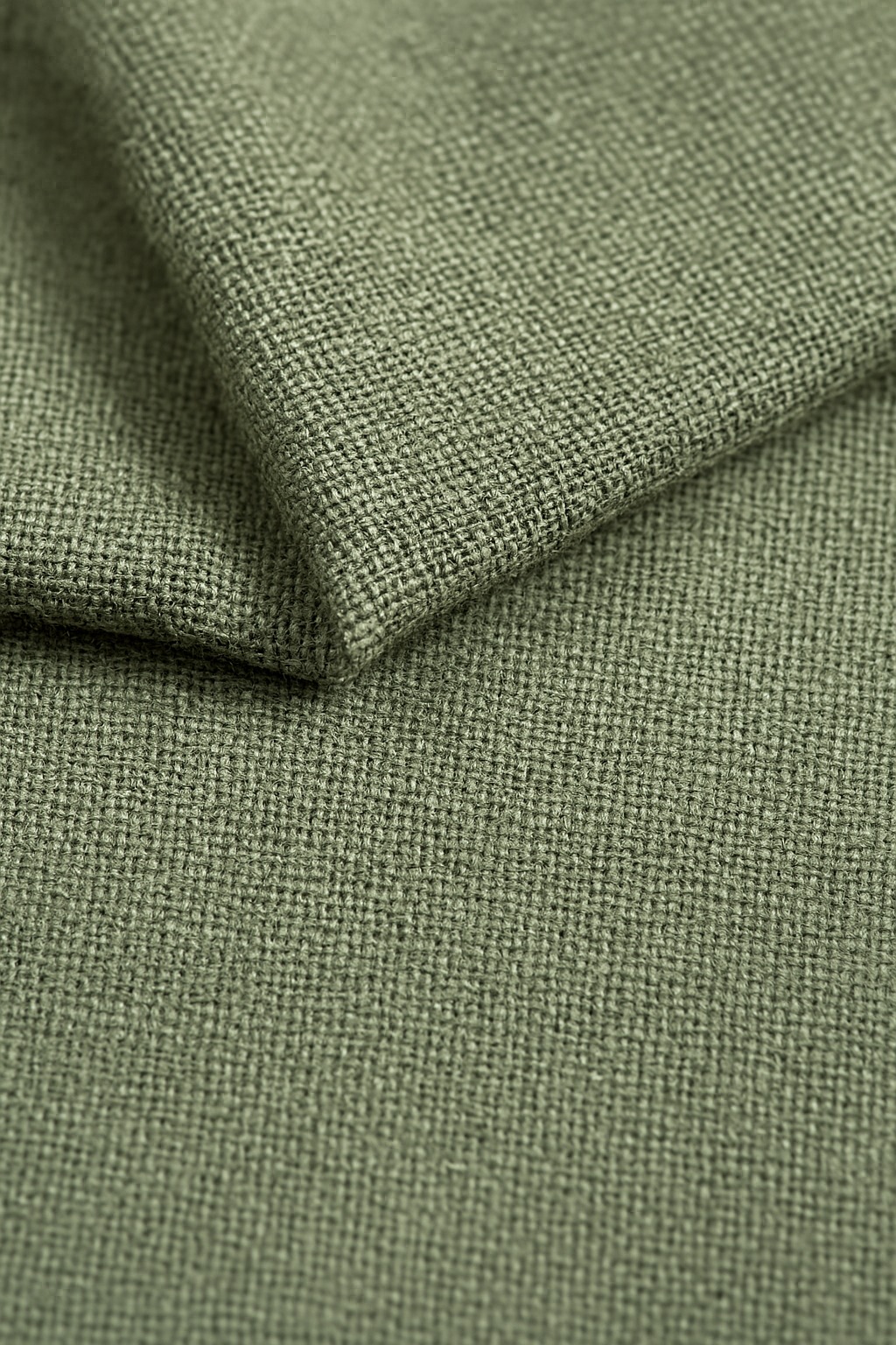 Close-up of sage green linen fabric texture